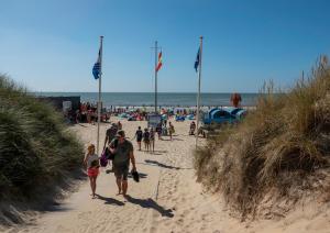 un grupo de personas caminando por una playa en Bed & Breakfast Bakker Meijer en Heemskerk