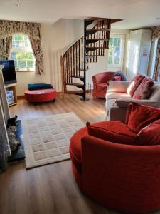a living room with a red couch and a staircase at The Annexe in Ulverston