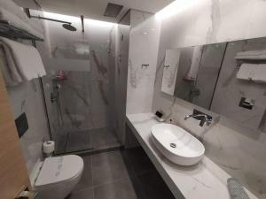 W łazience znajduje się toaleta, umywalka i prysznic. w obiekcie Minoa Hotel w mieście Tolo