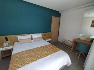 a bedroom with a large bed and a blue wall at Minoa Hotel in Tolo