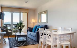 sala de estar con mesa y sofá azul en Duerming Sea View Viveiro, en Viveiro