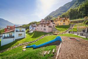a small village with a slide in the grass at Reka-Ferienanlage Magadino in Magadino