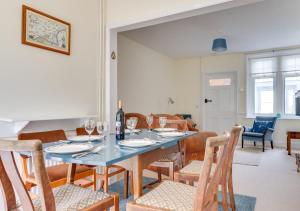 a dining room with a blue table and chairs at Cookies Coastguard Cottage in New Romney