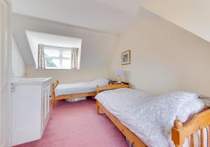 a bedroom with two beds and a window at Cookies Coastguard Cottage in New Romney