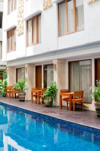 a hotel with a swimming pool in front of a building at The Sun Hotel & Spa Legian - CHSE Certified in Legian