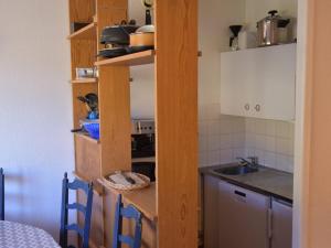 uma cozinha com armários de madeira, um lavatório e um balcão em Appartement Montgenèvre, 2 pièces, 6 personnes - FR-1-266-62 em Montgenèvre
