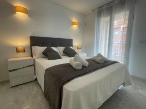 a white bedroom with a large bed with two pillows at Bonito Apartamento en el Centro de Moraira in Moraira
