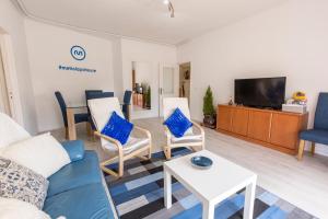 uma sala de estar com um sofá e cadeiras e uma televisão em Metro Lapa House with sunny balcony and A/C no Porto