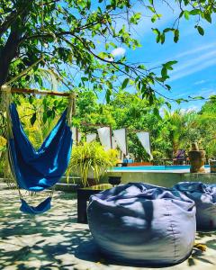 a hammock and chairs sitting under a tree at Richards Cabanas in Tissamaharama