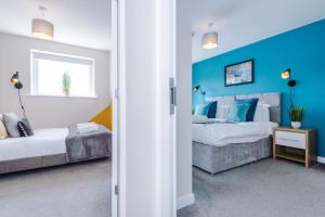 a bedroom with two beds and a blue wall at Hidden Gem within Central Chester - Great Location in Chester