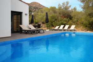 a pool with chaise lounge chairs and a swimming pool at Vila Mas Busca 72 - Roses Costa Brava in Roses