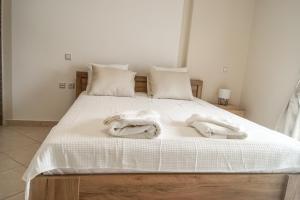 a bed with white towels on top of it at My Oneiro Apartments in Ioannina