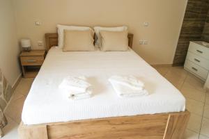 a bedroom with a bed with white towels on it at My Oneiro Apartments in Ioannina