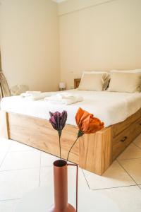 a bedroom with a large bed and a vase with flowers at My Oneiro Apartments in Ioannina