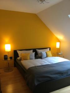 een slaapkamer met een groot bed met gele muren bij Komfort-Ferienwohnungen Walkmühle in Münstermaifeld