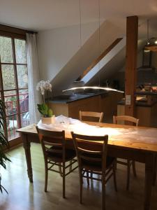 een keuken met een houten tafel met stoelen en een eetkamer bij Komfort-Ferienwohnungen Walkmühle in Münstermaifeld