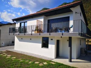 a white house with a balcony with bikes on it at Apartments Ole in Tolmin