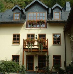 een groot wit huis met ramen en een balkon bij Komfort-Ferienwohnungen Walkmühle in Münstermaifeld