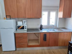 - une cuisine avec des placards en bois et un réfrigérateur blanc dans l'établissement Enjoy Oporto Campanha 2, à Porto