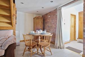 a dining room with a table and chairs and a brick wall at Character 1 Bedroom property with parking in Birmingham