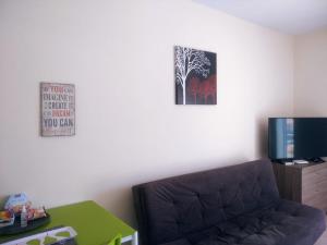 sala de estar con sofá y TV en Panoramic Holidays - Superior 41, en Peyia