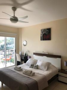 1 dormitorio con 1 cama grande y ventilador de techo en Panoramic Holidays - Superior 41, en Peyia