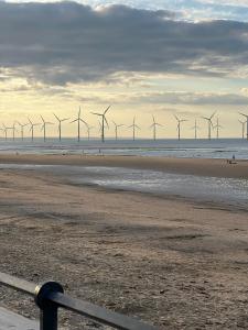 a beach with a row of wind turbines in the ocean at Normanby Raybould house in Normanby
