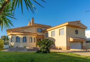 a house with a palm tree in front of it at Villa Los Olivos in Peniscola