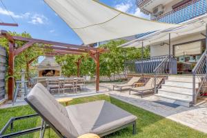 an outdoor patio with chairs and tables and a grill at Wellness Apartment in Poreč
