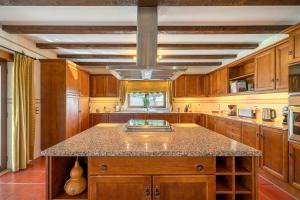 a kitchen with wooden cabinets and a granite counter top at Villa Junceira in Óbidos