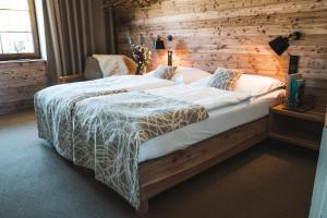 um quarto com uma cama grande e uma parede de madeira em Hotel Farma em Pelhřimov