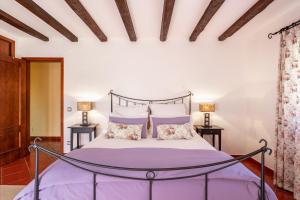 a bedroom with a bed with purple sheets and pillows at Villa Junceira in Óbidos