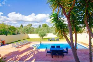 een patio met een tafel en stoelen naast een zwembad bij Villa Los Olivos in Peñíscola