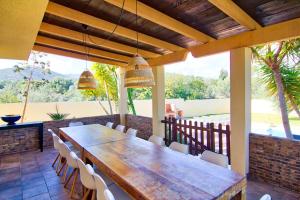 un patio con grande tavolo e sedie in legno di Villa Los Olivos a Peñíscola