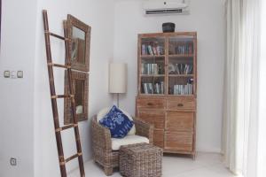 Habitación con silla, escalera y estante para libros. en Villa Sahaja, en Canggu