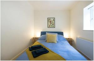 um quarto com uma cama azul com duas toalhas em Wells City Centre, Quiet Mews House, sleeps 6 em Wells