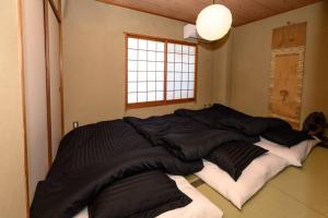 un grande letto nell'angolo di una stanza di G’Day Senbayashi ad Osaka