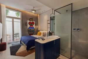 a bedroom with a bed and a sink and a shower at Alberto by Isrotel Design in Tel Aviv