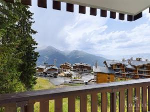 a balcony with a view of a town with mountains at Studio rénové skis aux pieds, balcon sud, parking inclus, proche commerces et garderie. - FR-1-398-512 in La Rosière