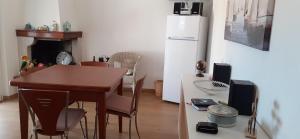 a kitchen with a table and a refrigerator at La Gabbianella - Locazione turistica in Marone