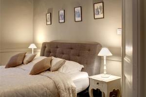 una camera con un letto e due lampade e quadri appesi al muro di B&B In Bruges a Bruges