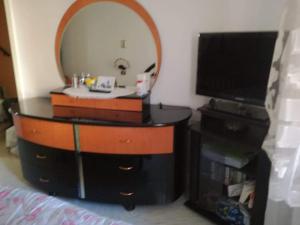 a dressing table with a mirror and a tv at A Za' Nella Avola in Avola
