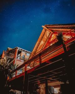a building with a wooden roof at night at Dreamland Beach House & Studios at Supertubes in Jeffreys Bay +88 photos