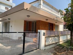 una casa blanca con una puerta y una valla en Kamala Holiday Home en Mysore