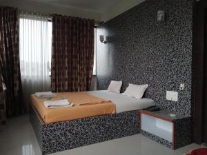 Schlafzimmer mit einem Bett mit einer schwarz-weißen Wand in der Unterkunft Malhar palace hotel in Shirdi