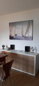 a table with a picture of sailboats on the wall at La Gabbianella - Locazione turistica in Marone +22 photos