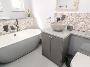 a bathroom with a tub and a sink and a bath tub at Craybourne in Falmouth