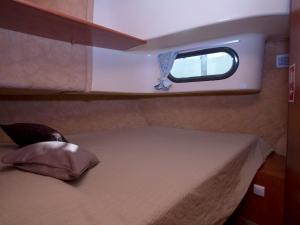 1 cama en la parte trasera de un barco con ventana en Amieira Marina, en Amieira