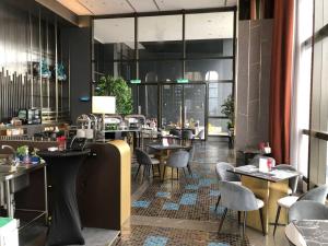 8 Kia Peng Residences by StayHere في كوالالمبور: مطعم بطاولات وكراسي ونوافذ