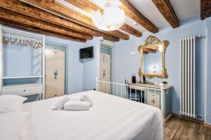 a bedroom with a white bed and a mirror at Piccolo Vecellio in Venice